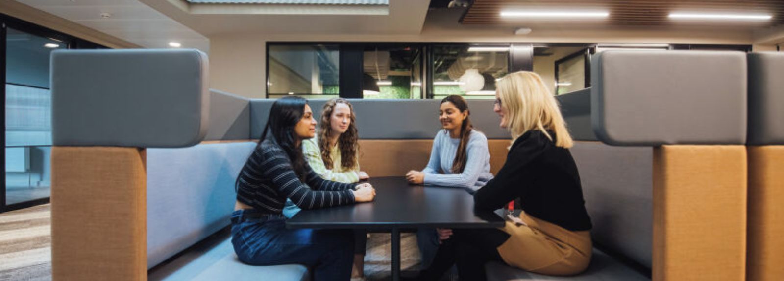 Four staff members sitting around a table in a sheltered area
